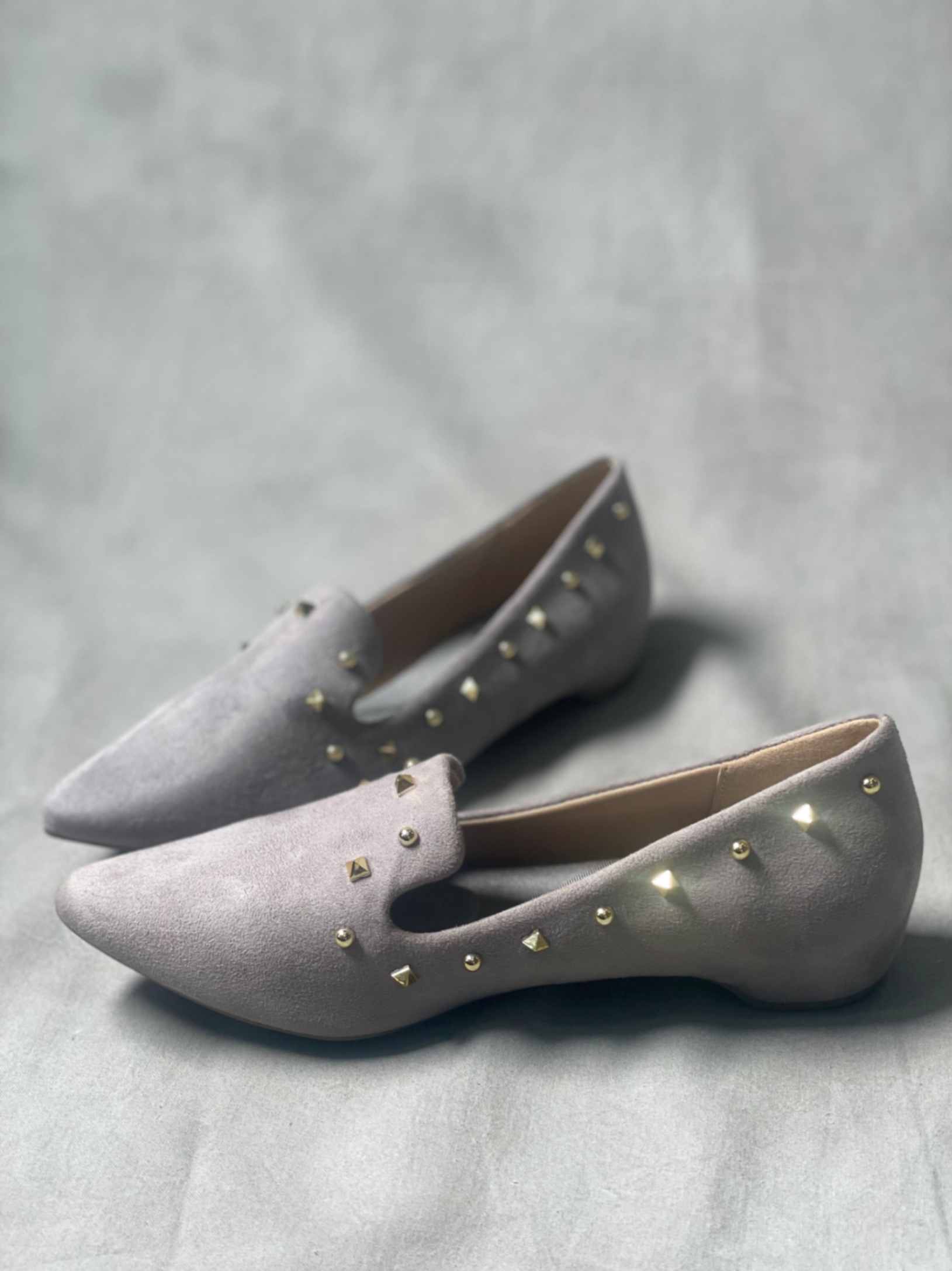 Side view of grey suede loafers for women, showcasing their sleek, slip-on design.