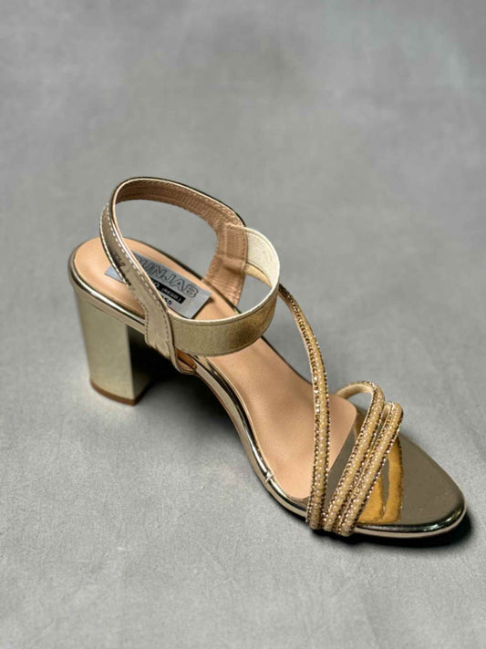 Golden ankle strap heels with a metallic finish, block heel, and elegant toe design, perfect for formal or party wear.