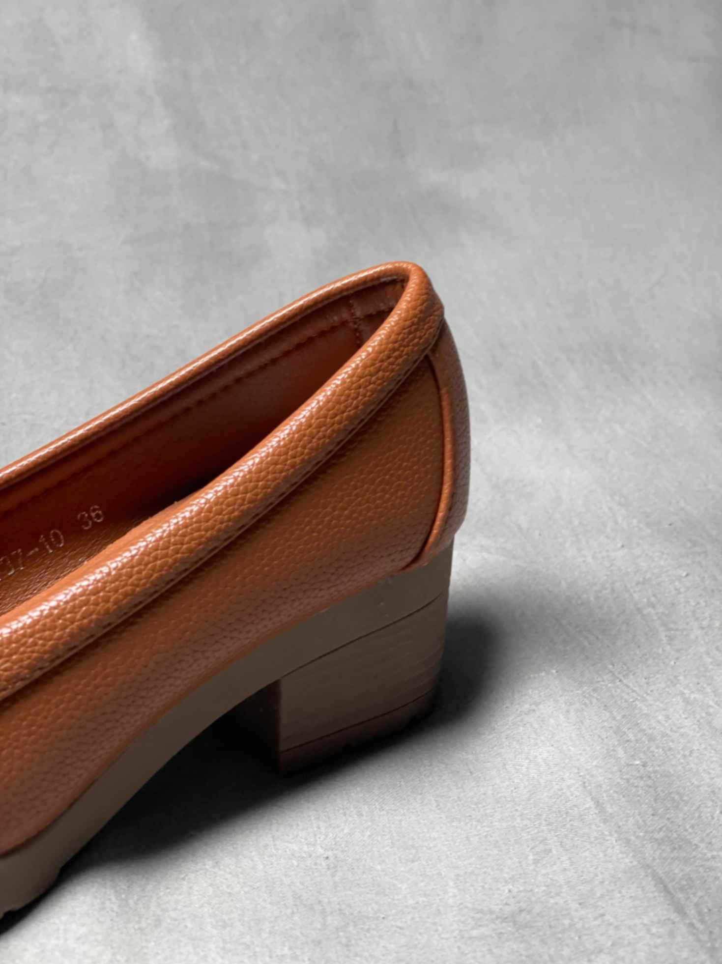 Side view of brown heeled loafers with buckle, featuring a textured finish and sturdy block heel for versatile styling.