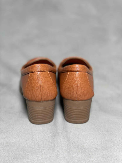 Rear view of brown heeled loafers with buckle, highlighting the block heel and seamless stitching for a polished look