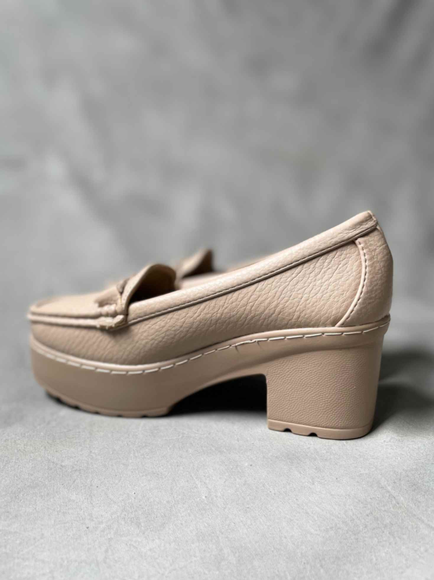 Side view of beige heeled loafers with buckle, featuring a textured finish and sturdy block heel for versatile styling.