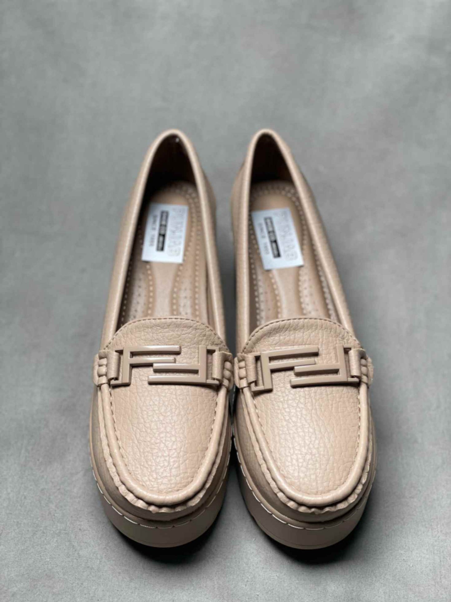 Top view of beige heeled loafers with buckle, showcasing detailed stitching and a cushioned insole for added comfort.