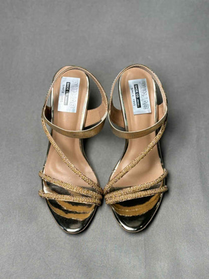 Pair of golden heels with adjustable ankle straps, glittery detailing, and a pointed toe, ideal for women’s evening attire.